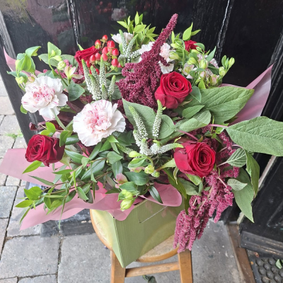 Ruby Romance Bouquet - A luxurious gift box of deep red roses, blush striped carnations, trailing burgundy amaranthus and white veronica, set among lush foliage. A passionate, elegant gesture.