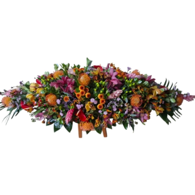 Everlasting Love Spray - A striking casket spray in rich orange, pink and burgundy tones, beautifully arranged with lush greenery for a vibrant and heartfelt tribute. 3ft